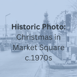 Historic photograph of Market Square Lisburn at Christmas time with tree in centre of town and traffic passing.