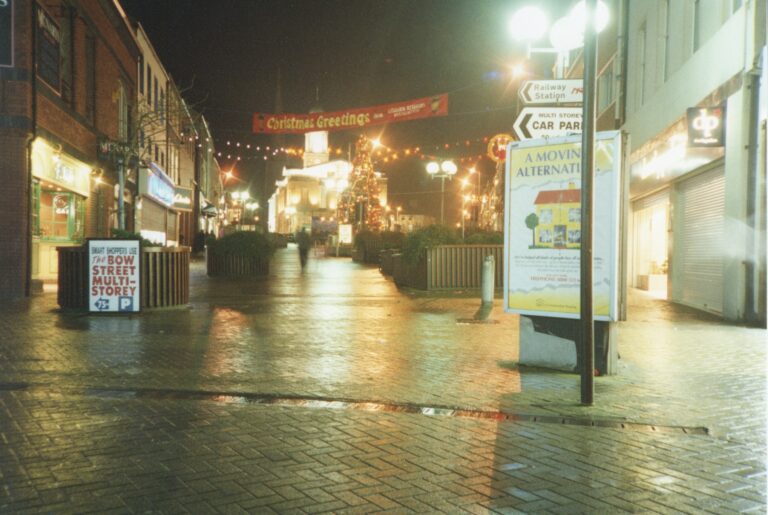 Market Square at night with Christmas decorations hanging across street, Lisburn Christmas tree lit in front of Lisburn Museum, 1994.