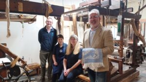 A photograph of Fabrice, with Donna and Alison in the Weaving Workshop